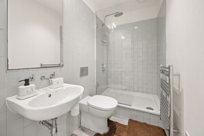 Ein modernes Badezimmer mit Waschbecken, Toilette und Dusche.