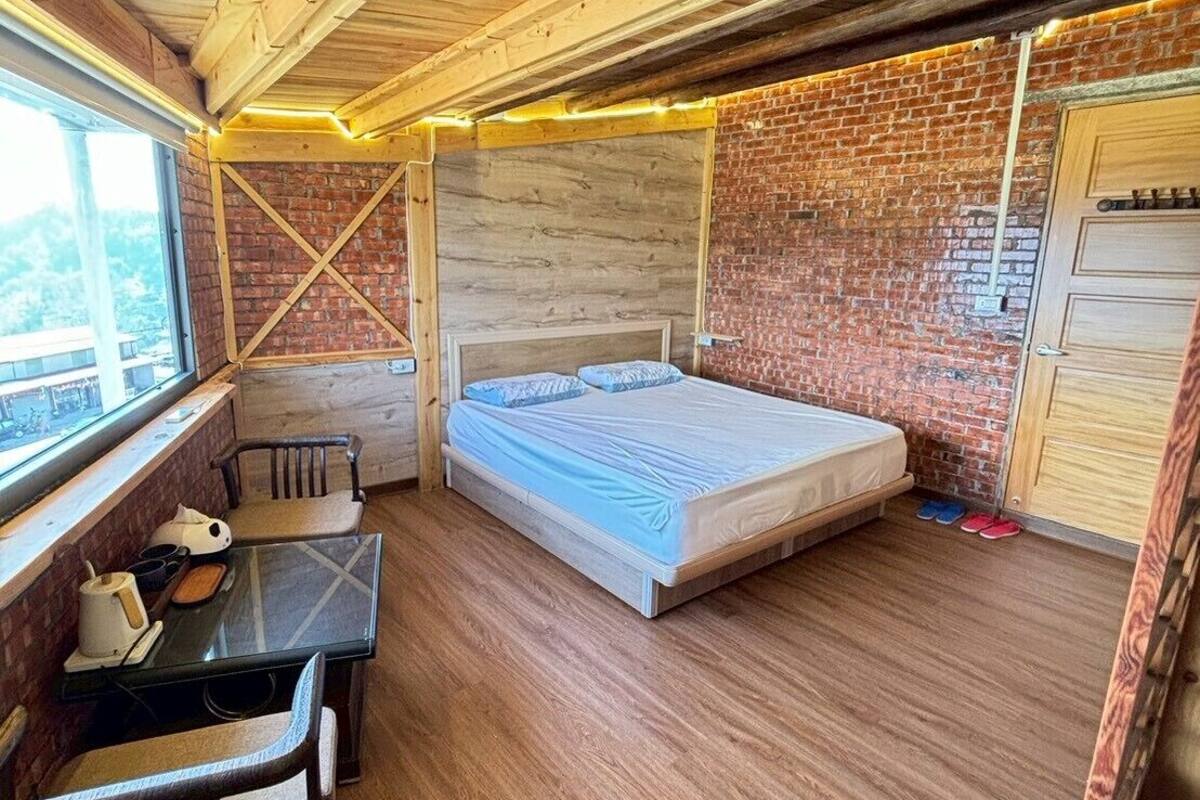Ein kleines Zimmer mit Bett, Tisch und Fenster.