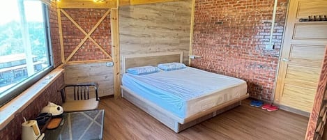 A compact room with a bed, a small table, and a window.