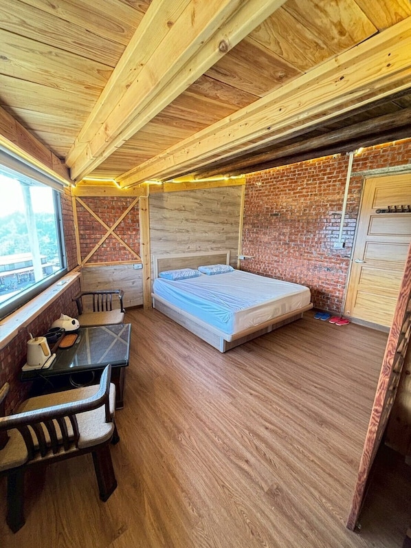 A compact room with a bed, a small table, and a window.