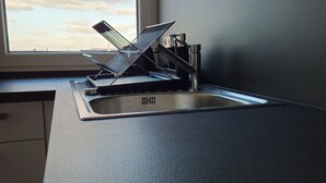 Eine Küche mit einem modernen Spülbecken, einem Fenster mit Blick zum Himmel und einer Arbeitsplatte.