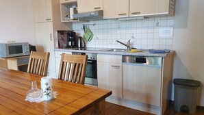 A compact kitchen with wooden cabinets, a microwave, a coffee maker, and a sink.
