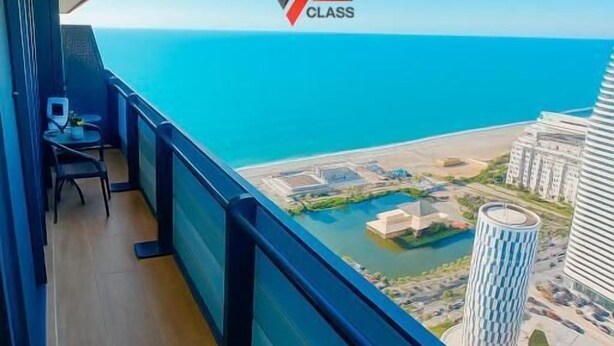 Un balcón con vistas al mar y al paisaje urbano.