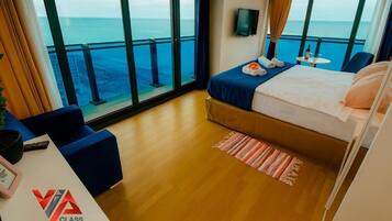 Suíte panorâmica, sacada, vista para o mar | Escrivaninha, espaço de trabalho para notebook, cortinas blackout