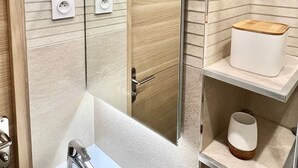 A modern bathroom with a glass shower enclosure, a white sink, and a wooden shelf with a cup. - Superb Studio teletravail - Rooftop Paris (Saint-Ouen-sur-Seine)