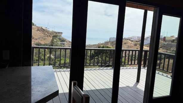 A balcony with a view of a hilly landscape and the ocean. - Beautiful Ocean View Cabin by k38 (Playas de Rosarito)
