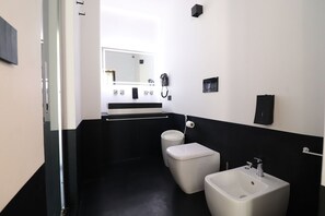 Un bagno moderno con una palette di colori bianco e nero, che include un WC, un bidet e un lavabo.
