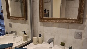A bathroom with a white sink, two mirrors with ornate frames, a towel rack, and a small plant. - Large Studio very well located! 100m tramway, 5 minutes downtown, 10min beach! (Nice)