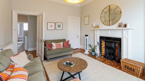 A living room with a fireplace, a sofa set, a coffee table, and a hanging light fixture. - Gorgeous 2BDR with Unique Character in Edinburgh (Edinburgh)