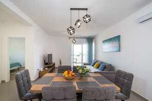 Un soggiorno moderno con zona pranzo, divano e un quadro appeso al muro.