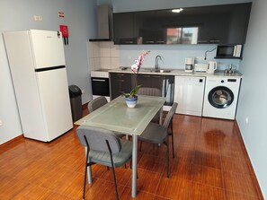 A compact kitchen with a refrigerator, microwave, sink, and washing machine. - Golden Sun Refuge (Estreito da Calheta)