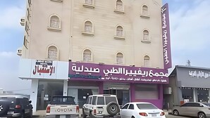 A multi-story building with several shops on the ground floor, including a hotel and a car dealership. - agnehat alsmo hotel (Al Aydabi)