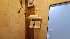 A bathroom with a shower, a toilet, and a towel rack with towels. - agnehat alsmo hotel (Al Aydabi)