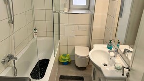 Et moderne badeværelse med badekar, toilet og håndvask.