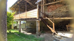 A rustic building with a wooden balcony and stone walls.