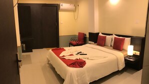 Une chambre d’hôtel équipée d’un lit, d’une table de chevet, d’une petite table et d’un climatiseur fixé au mur.