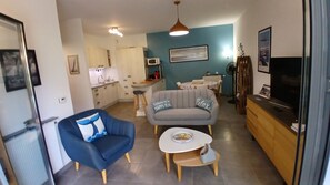 A modern living room with a sofa, a coffee table, and a television. - Relax and enjoy comfort in this apartment near the port. Wi-Fi. Secure parking. (Arcachon)