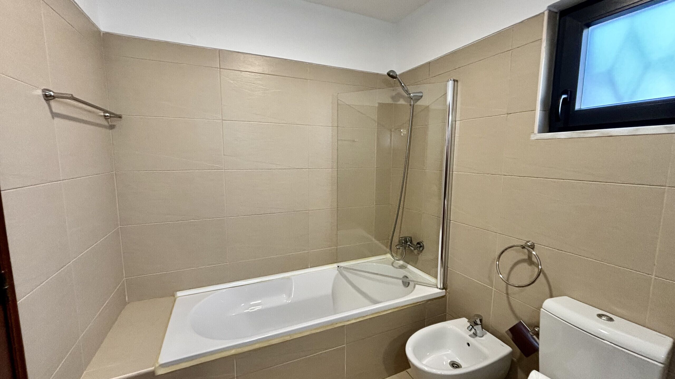 A bathroom with a bathtub, a shower, a sink, and a toilet.