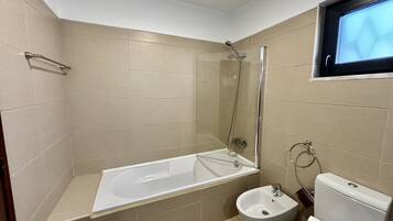 A bathroom with a bathtub, a shower, a sink, and a toilet.