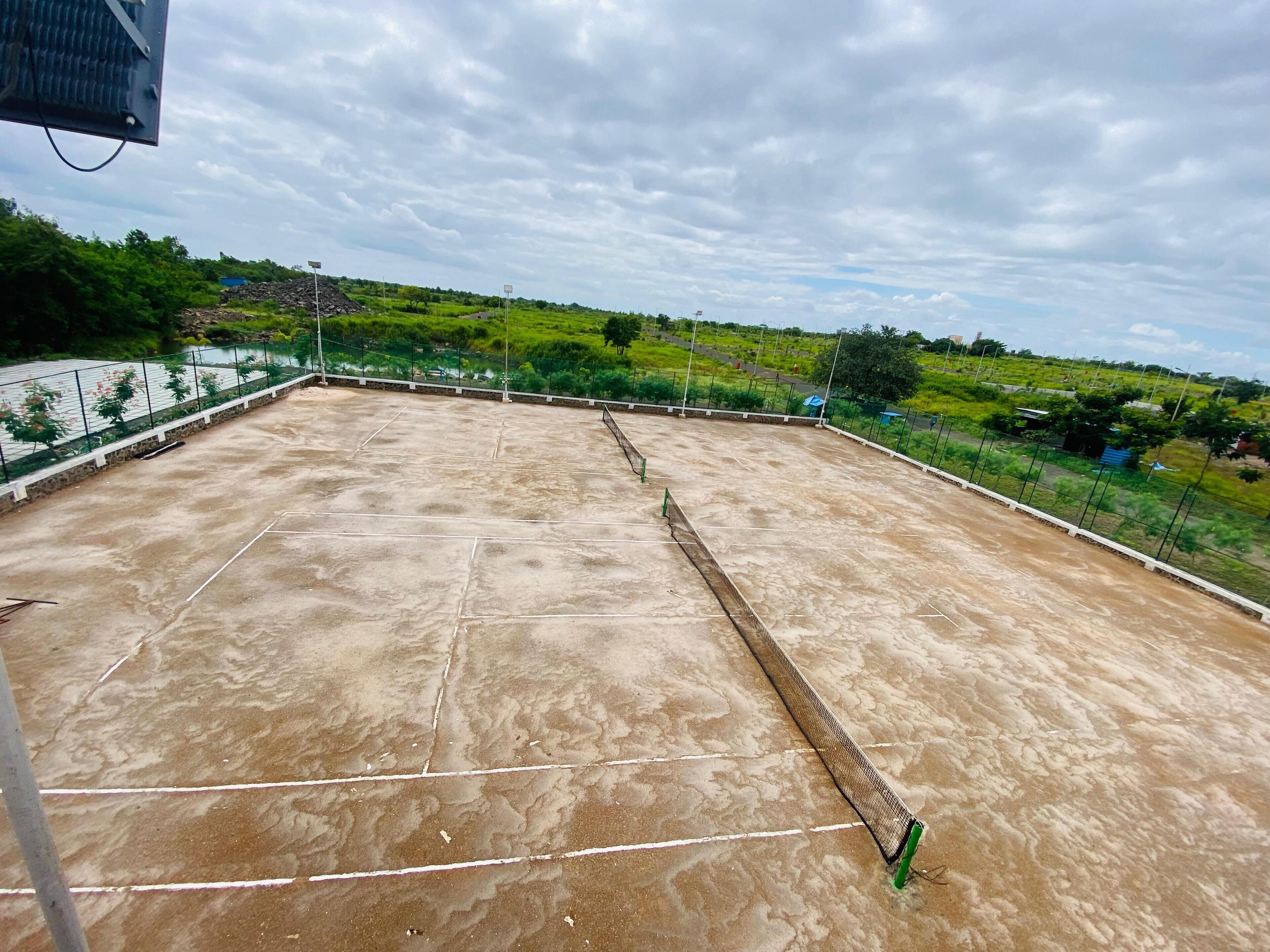 A rooftop with a concrete surface, marked lines, and a metal railing.