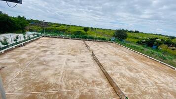 A rooftop with a concrete surface, marked lines, and a metal railing.