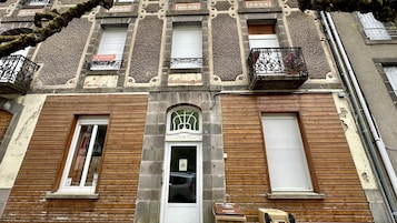 Un edificio con fachada de madera, varias ventanas y balcones.