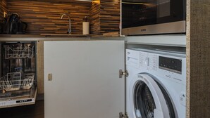 A compact kitchen with a built-in dishwasher, a microwave, and a washing machine. - Plovdiv City Centre One-Bedroom Apartment View Fully Equipped Kitchen City View (Plovdiv)
