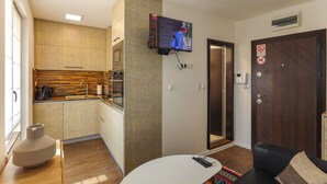 A modern living room with a TV mounted on the wall, a sofa, and a coffee table. - Plovdiv City Centre One-Bedroom Apartment View Fully Equipped Kitchen City View (Plovdiv)