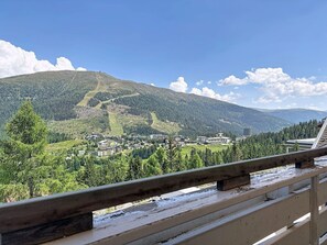 A mountain landscape with a town nestled in the valley, a clear sky, and a wooden railing in the foreground. - Lovely apartment for 2 people with WIFI, TV, balcony and pets allowed (St Michael Im Lungau)