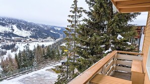 A balcony with a view of a snowy mountain landscape, including a ski resort and a road. - Nice apartment for 6 people with WIFI, TV, balcony and pets allowed (St Michael Im Lungau)