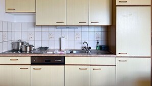 A kitchen with light wooden cabinets, a dishwasher, a stove, and a sink. - Nice apartment for 6 people with WIFI, TV, balcony and pets allowed (St Michael Im Lungau)