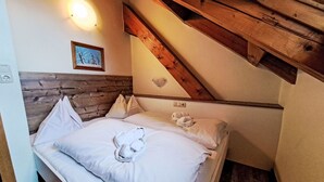 A bedroom with a wooden headboard, a bed with white linens, a framed picture on the wall, and a light fixture above the bed. - Beautiful apartment for 6 guests with WIFI, TV, balcony and pets allowed (St Michael Im Lungau)