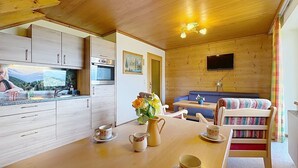 A cozy cabin interior with a kitchen, dining area, and seating space. - Beautiful apartment for 6 guests with WIFI, TV, balcony and pets allowed (St Michael Im Lungau)