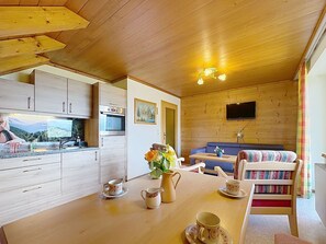 Ein gemütliches Blockhaus-Interieur mit einer Küche, einem Essbereich und einer Sitzecke.