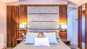 Ein Schlafzimmer mit einem großen Bett, einem Holzschrank und zwei Nachttischlampen.