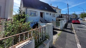 A residential street with houses, a red car parked on the side, and a clear sky. - Spacious house for large family or group - Near Villejuif Metro Line7 (Villejuif)