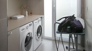 A laundry room with two washing machines, a drying rack, and shelves with folded towels. - Stunning Villa With Pool in Sukosan (Sukosan)