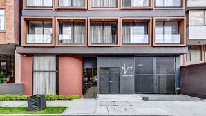 A modern building with a flat facade, large windows, and a visible storefront with the name "FLAT 9". - w Inviting Loft w Balcony in Usaquen (Bogotá)