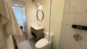 Ett modernt badrum med toalett, handfat och dusch.