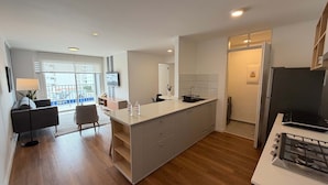 A modern kitchen with a central island, built-in appliances, and a view to the outside. - w Chic Inviting 2BR w Balcony in Miraflores (Lima)