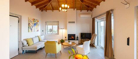 A cozy living room with a wooden ceiling, a sofa, a TV, and a fireplace.
