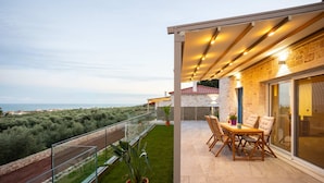 Ein Balkon mit Glasgeländer und Blick auf die Küstenlandschaft.