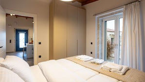 Ein Schlafzimmer mit einem großen Bett, einem Kleiderschrank und einem Fenster mit Vorhängen.