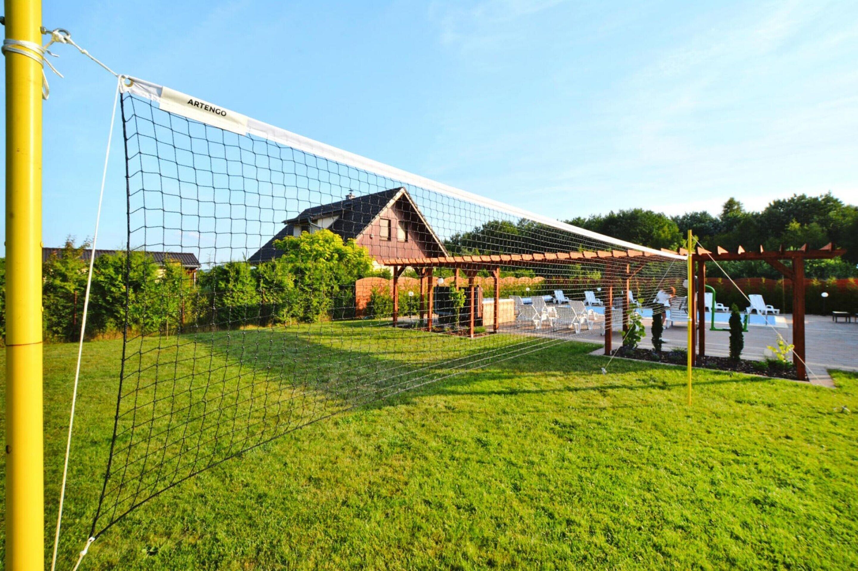 A netted sports area with a pavilion and outdoor seating.
