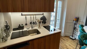 Une cuisine moderne avec des meubles en bois, un évier en acier inoxydable et un plan de travail noir.