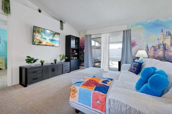 Een slaapkamer met een bed, een televisie, een kaptafel en een raam met uitzicht.