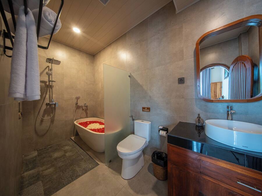 A modern bathroom with a bathtub, toilet, and sink.