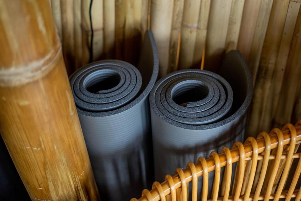 Two rolled-up mats in a woven basket.