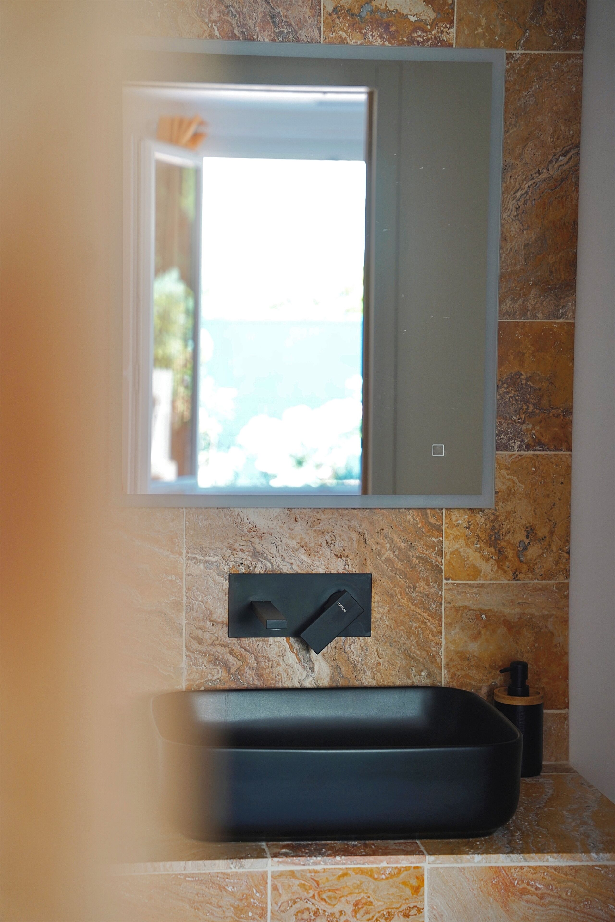 Ein Badezimmer mit integriertem Waschbecken, einem Spiegel und Meerblick.
