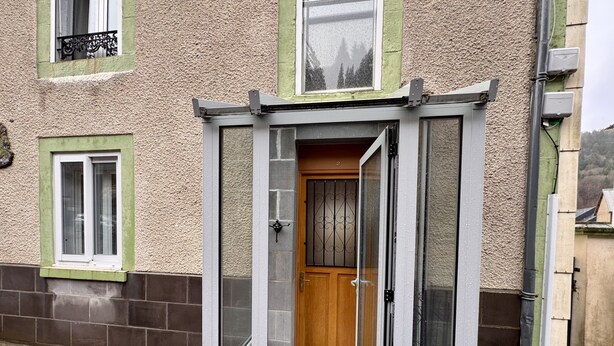 A small, enclosed entrance with a wooden door and a glass door, leading to a tiled entrance area. - Romantic Cocoon With Private Garden (Mont-Dore)
